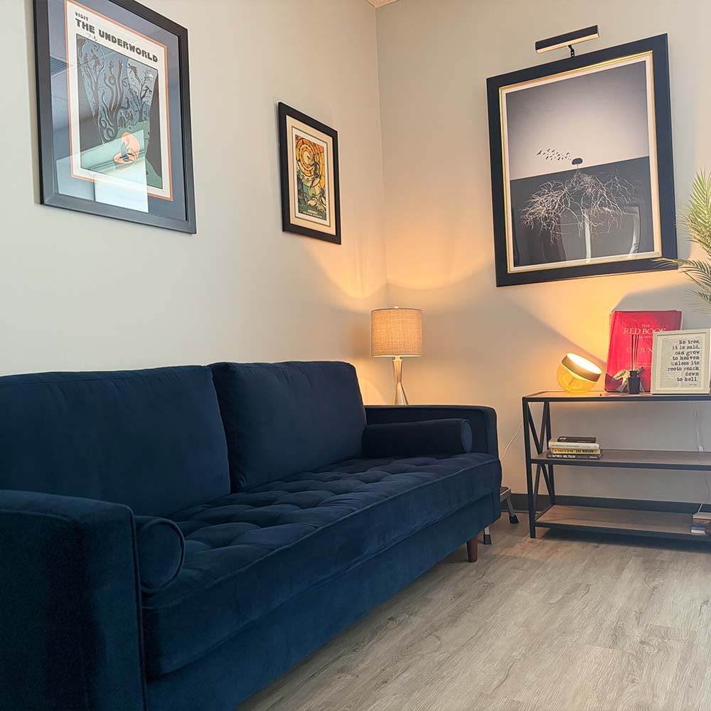 Therapy office with blue couch and modern decor at Massachusetts Center for Addiction.