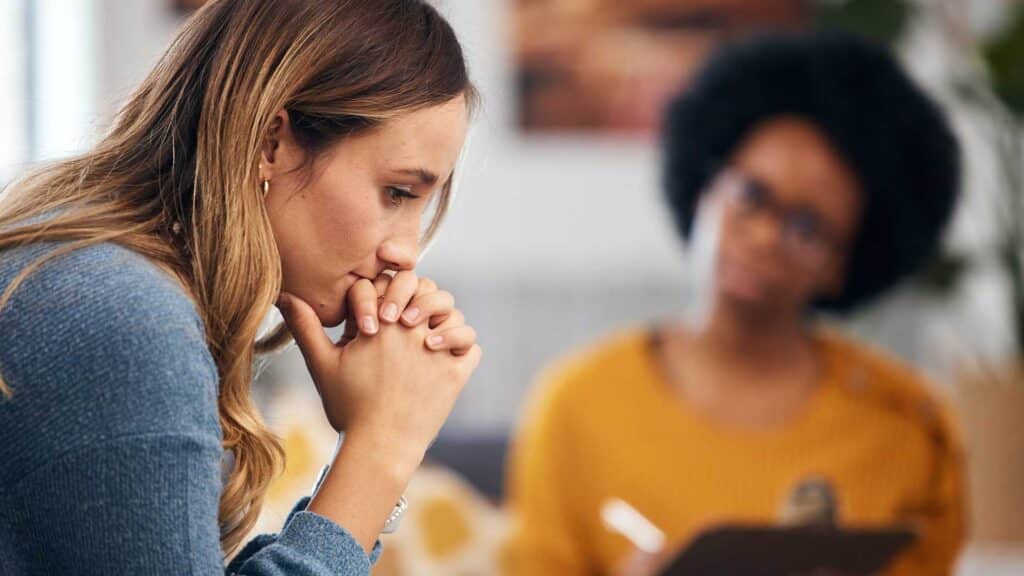 Woman sitting with female therapist during dual diagnosis treatment in individual therapy session.