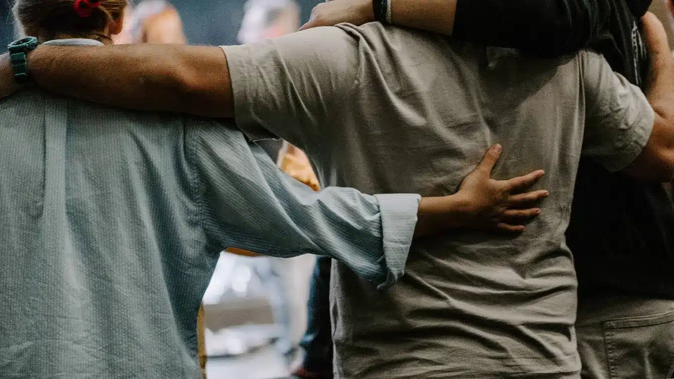 a person hugging another person during support group for aftercare in drug addiction recovery