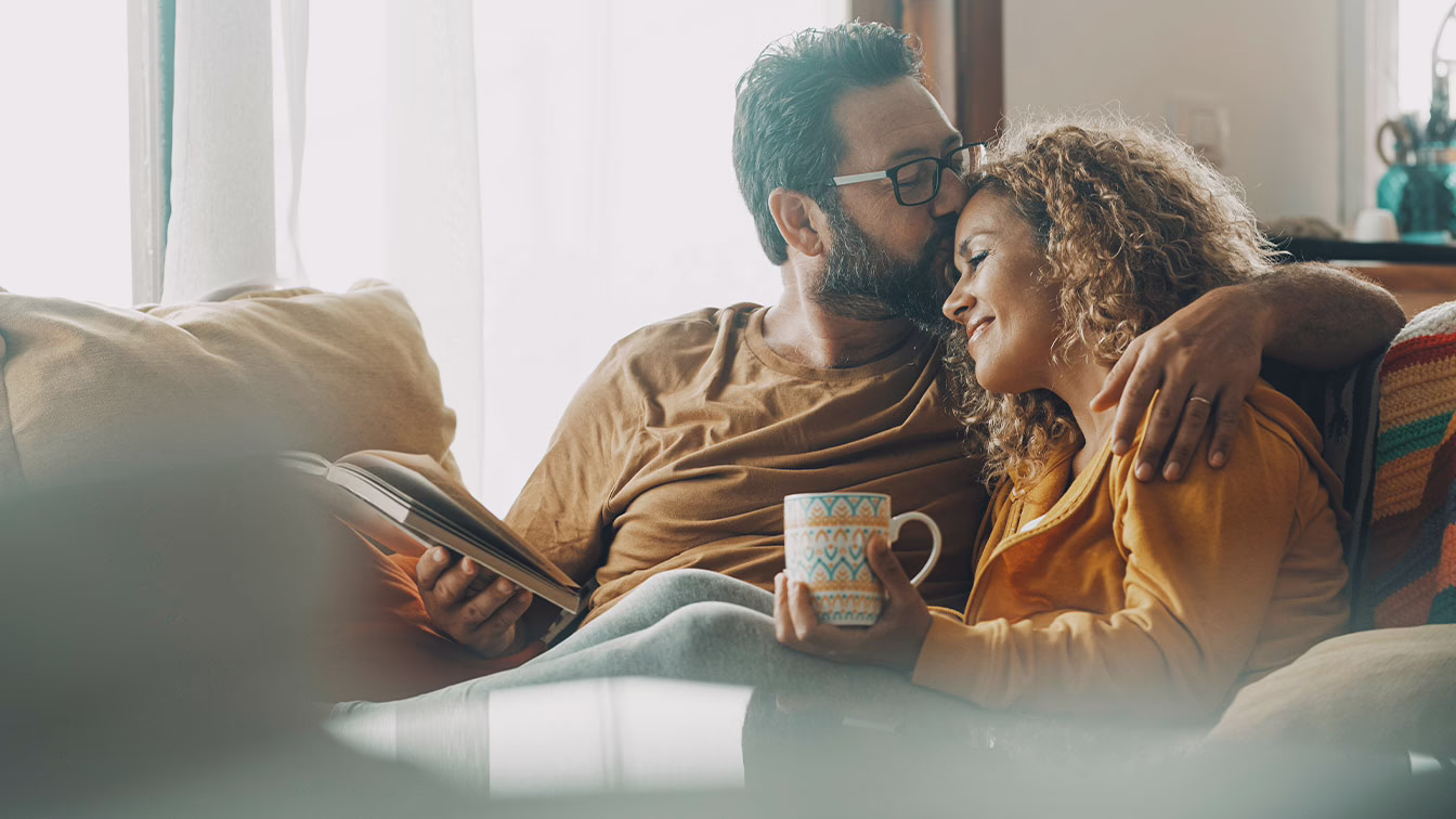 happy couple on their couch after seeking addiction treatment later in life
